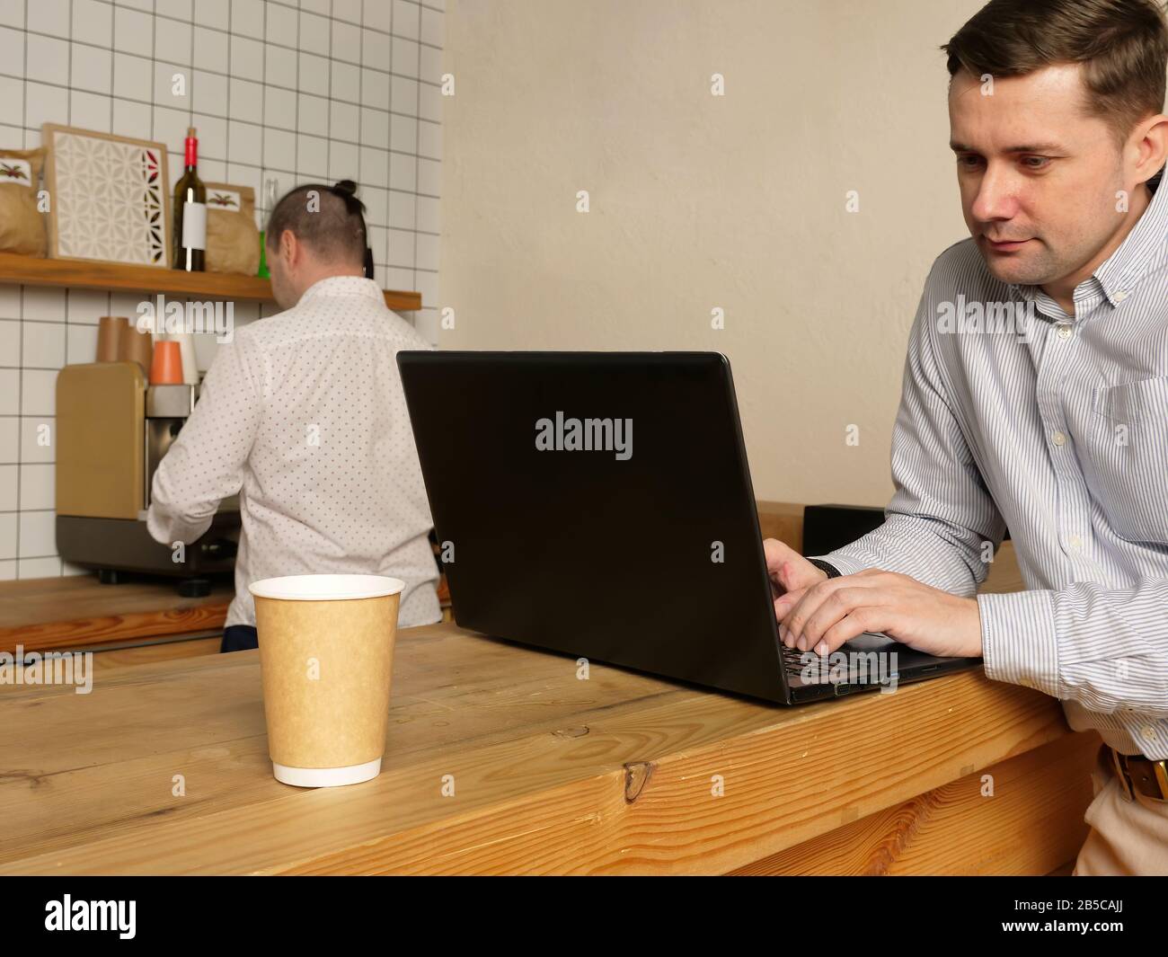 Thoughtful man writer typing on laptop keyboard in the cafe. Stock Photo