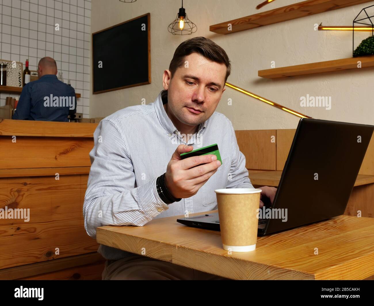Man is shopping online with credit card in cafe. Stock Photo