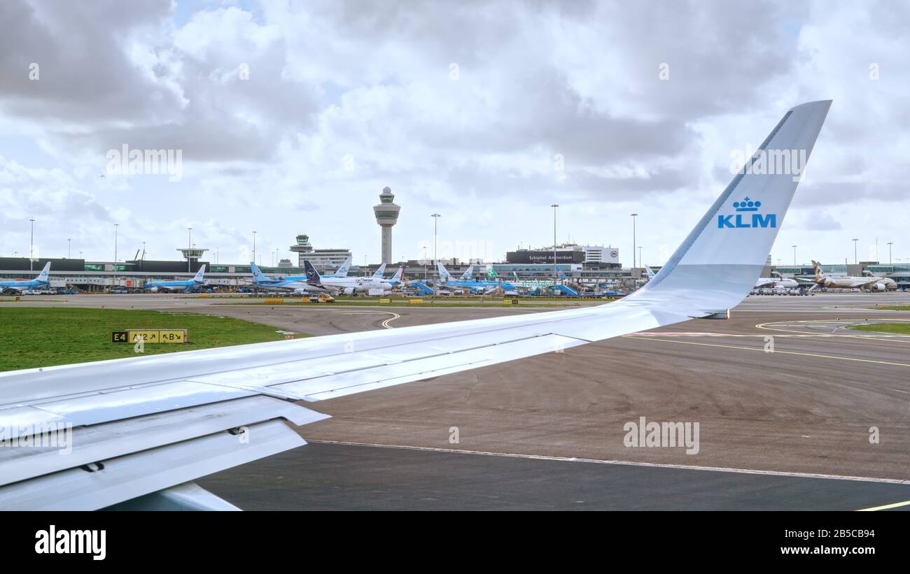 KLM Royal Dutch Airlines plane takes off in Amsterdam Schiphol International Airport, Netherlands. Apron with airplanes and Air Traffic Control Tower. Stock Photo
