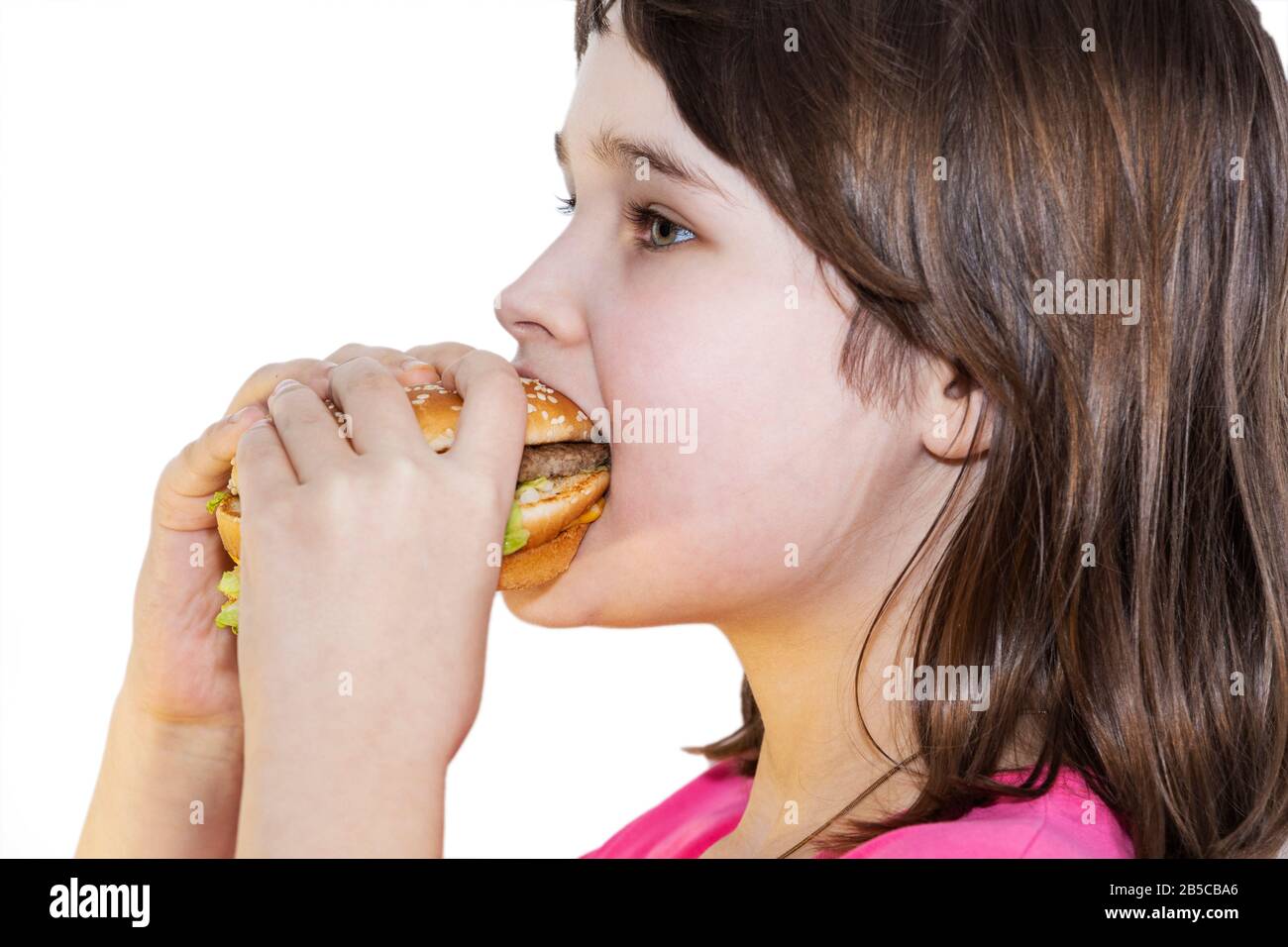 portrait of a beautiful girl, teenager and schoolgirl, holding a hamburger on a white background. Stock Photo