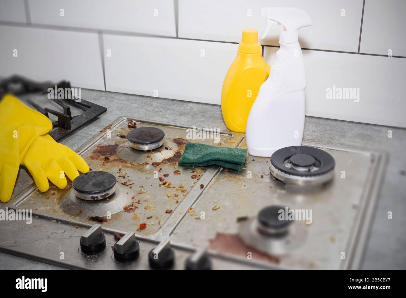 Cleaning a gas stove with kitchen utensils, household concepts, or