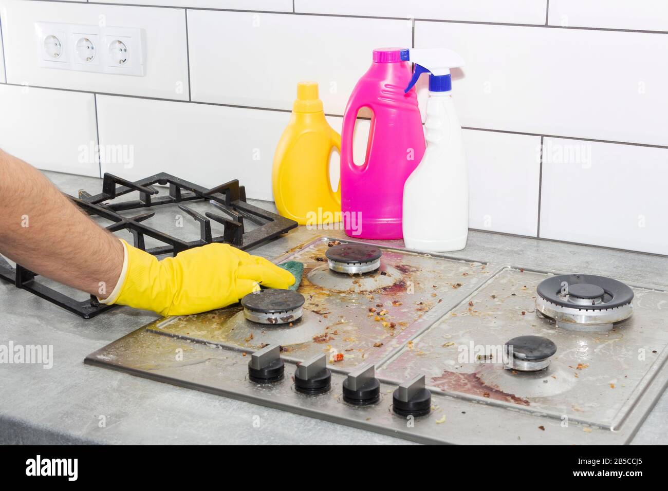 Cleaning a gas stove with kitchen utensils, household concepts, or hygiene and cleaning Stock