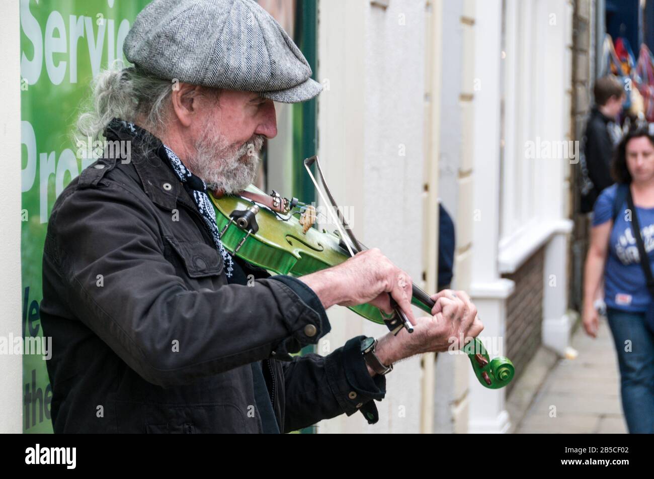 A street busker playing his violin in the streets of Whitby on the east