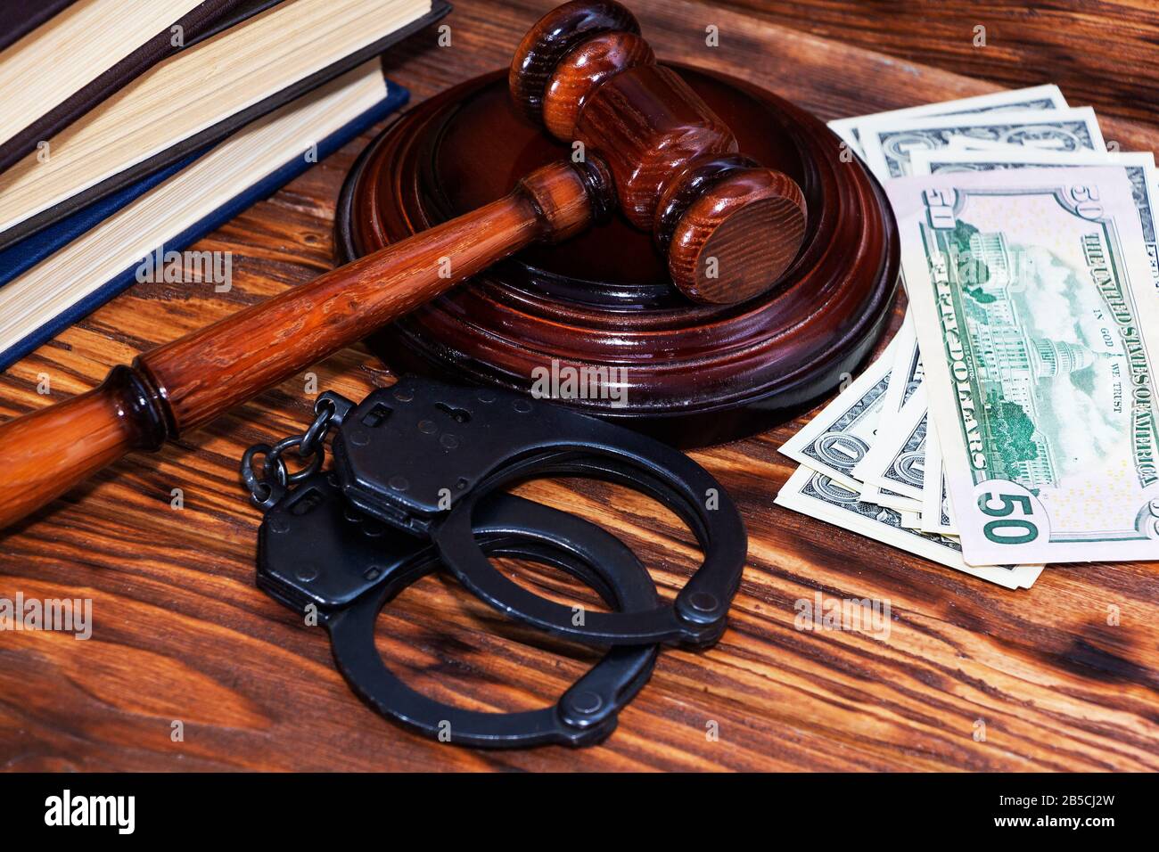 Handcuffs and a wooden gavel in front of manila folders Stock Photo