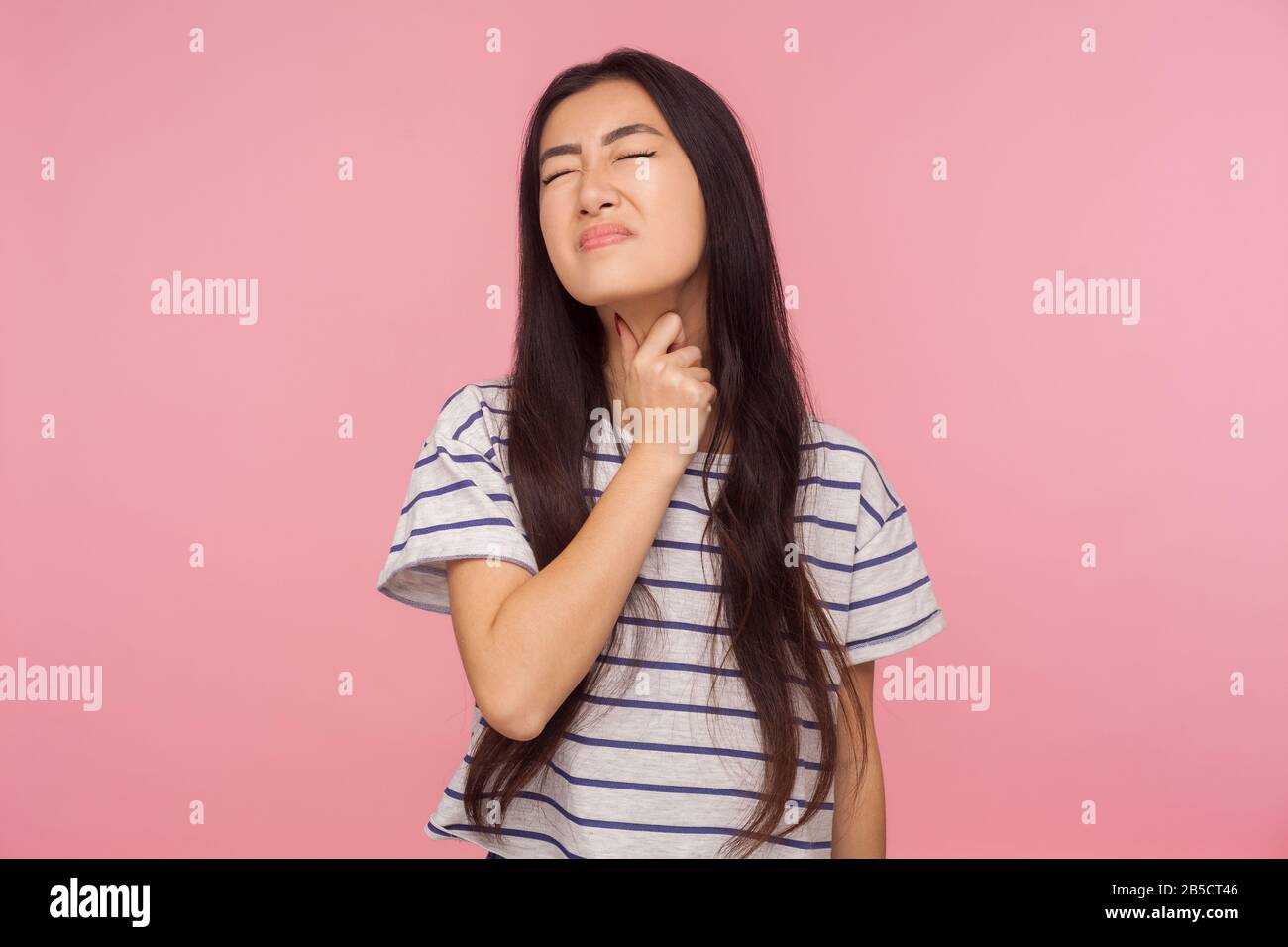 Sore throat. Ill girl with hair in striped tshirt touching