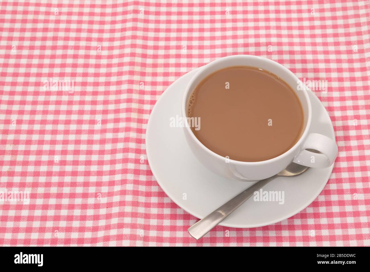 Cup of tea placed on a checked pattern tablecloth Stock Photo