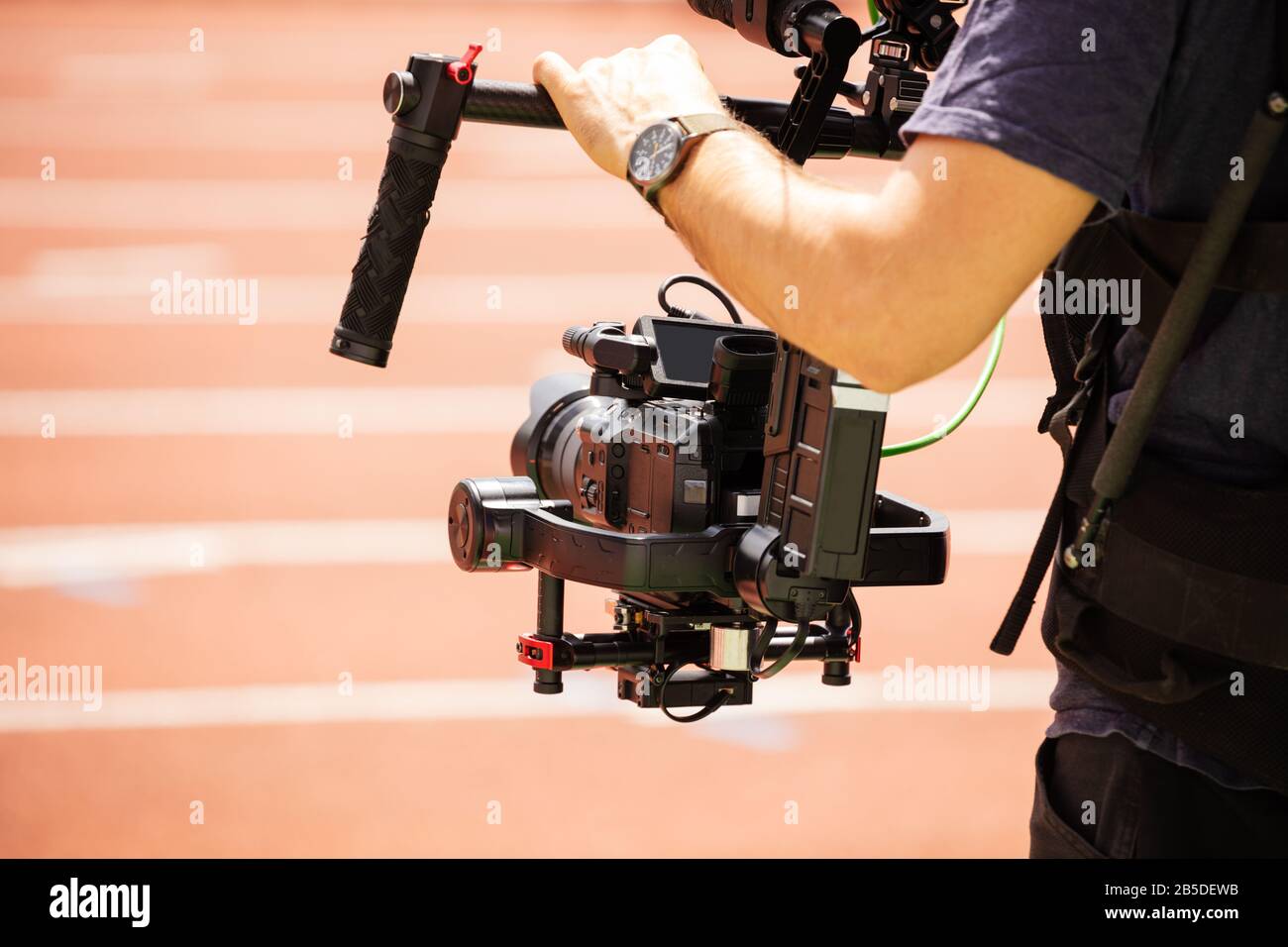 Close-up of camera-man shooting sport track competition view from the back Stock Photo