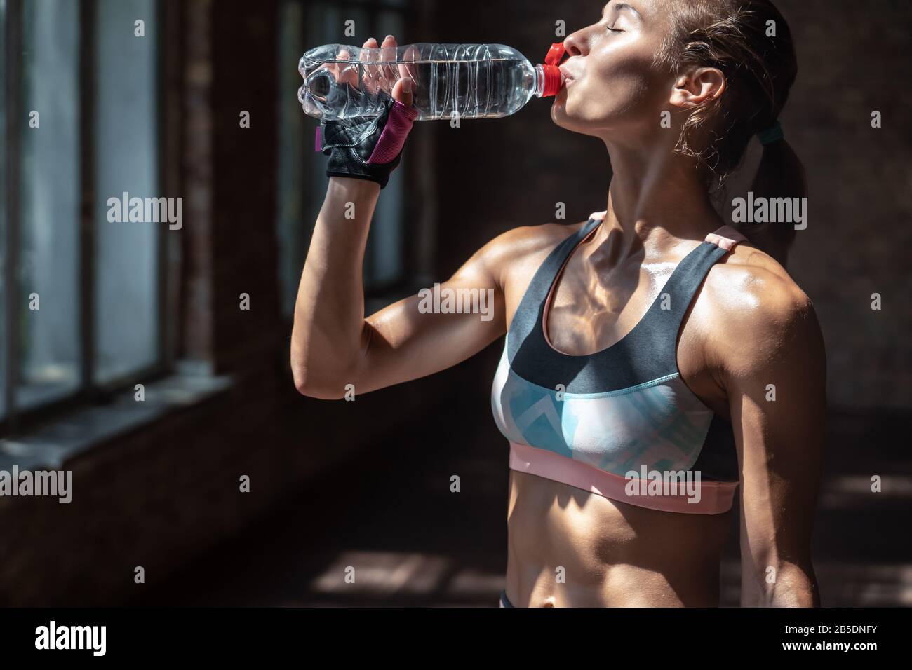 Sporty thirsty woman fitness trainer drink water have break. Stock Photo