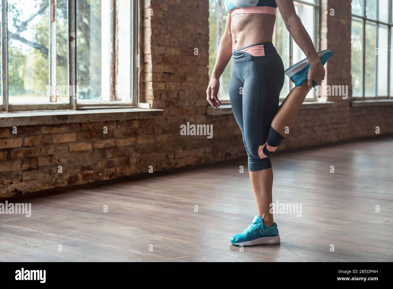 Sporty young woman fitness coach warm up stretch leg. Stock Photo