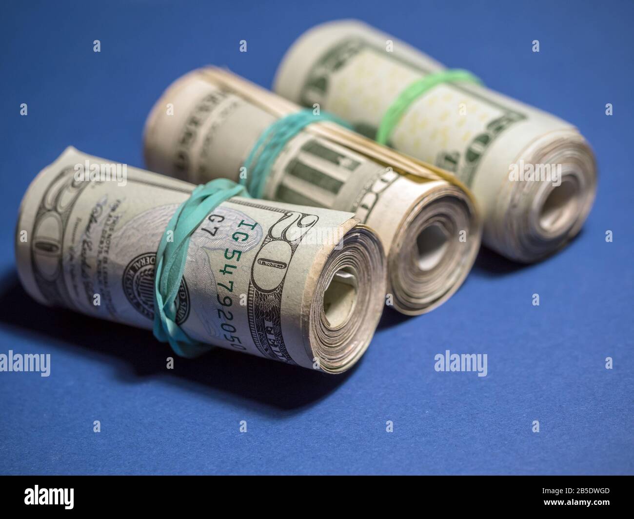 Rolls of American dollar bills on blue background Stock Photo