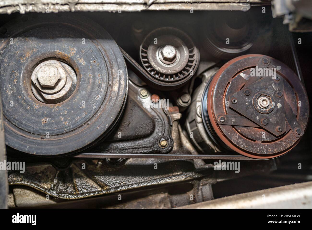 Crankshaft pulley connected by a multiribbed belt with tensioner and