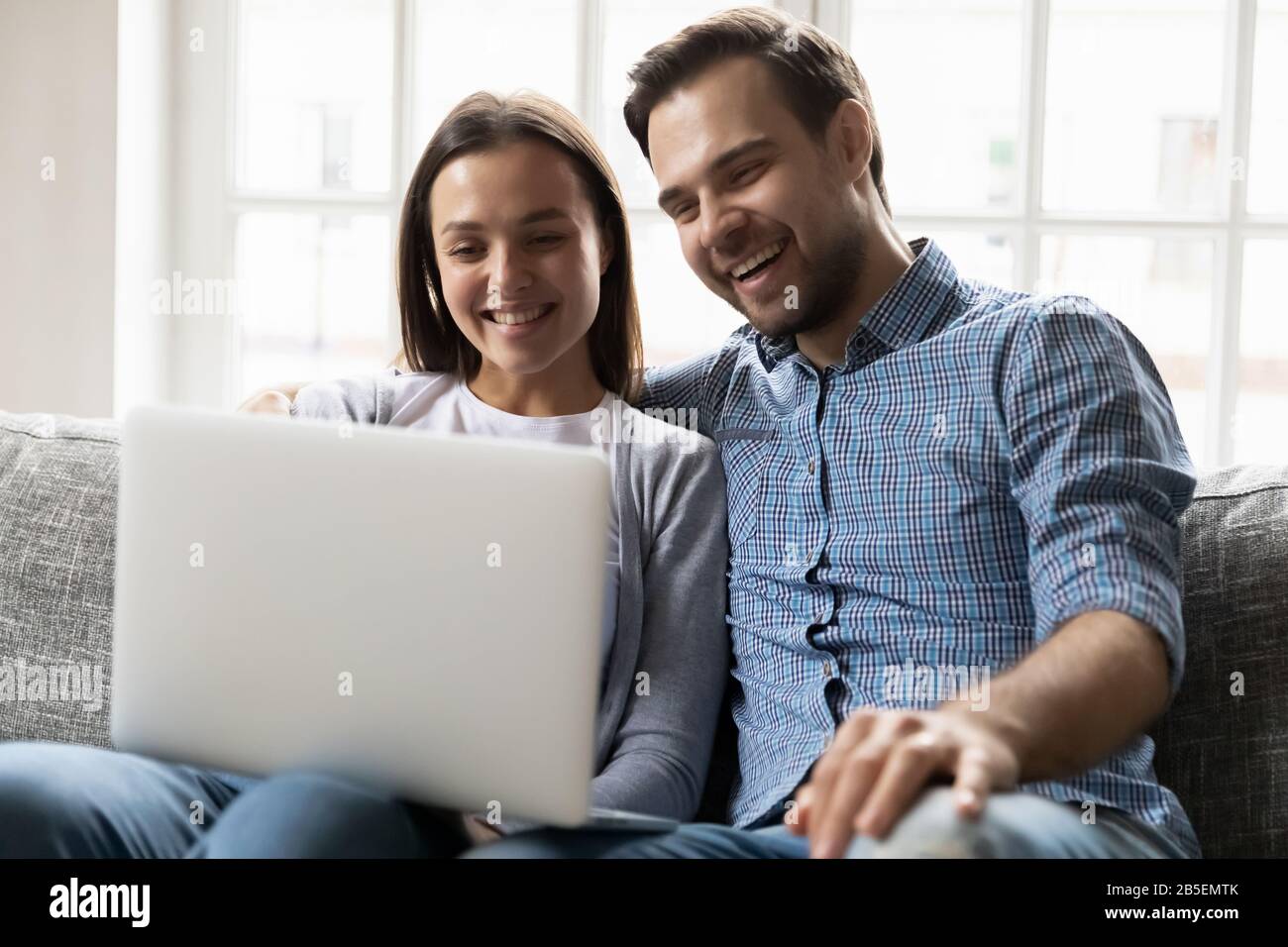 Happy married couple watching funny video on computer Stock Photo - Alamy