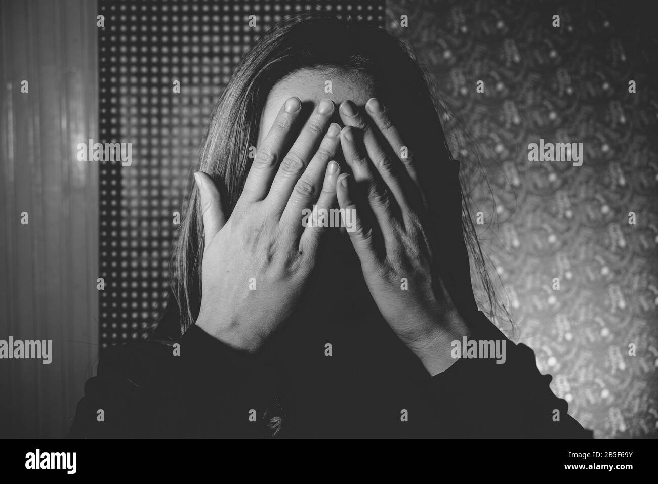 scared woman cover her eyes with hands afraid and abused hiding Stock Photo