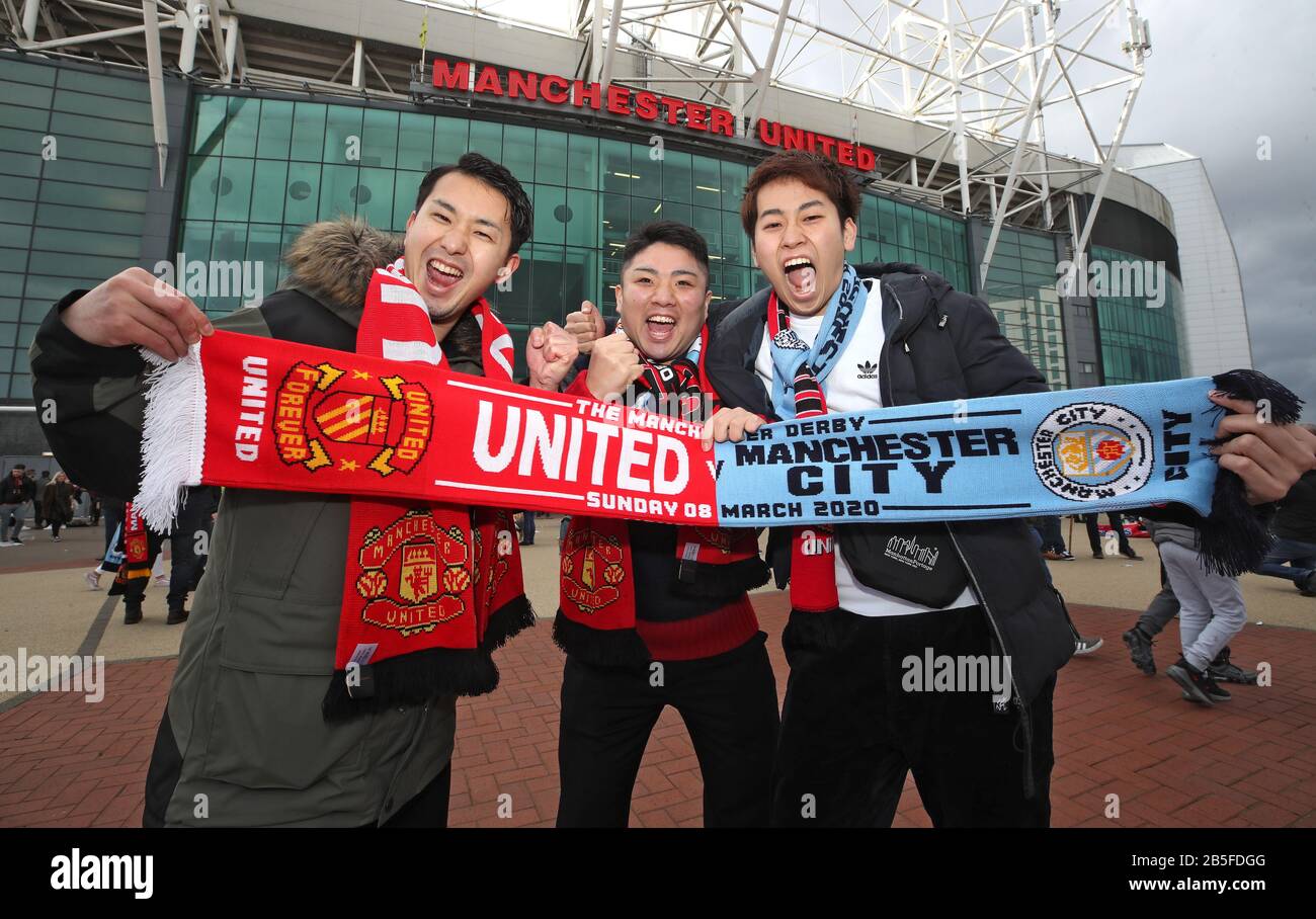 Fans hold up a half and half scarf during the Premier League match at Old Trafford, Manchester. Stock Photo