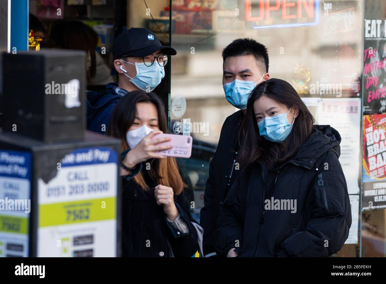 Liverpool, UK. 8th Mar 2020.  A group of people wearing face masks appear to pose for a selfie. People in Liverpool, north-west of England wearing face masks in the main shopping district of the city centre. The UK Government announced today that 273 people have tested positive for Coronavirus in the United Kingdom. Credit: Christopher Middleton/Alamy Live News Stock Photo
