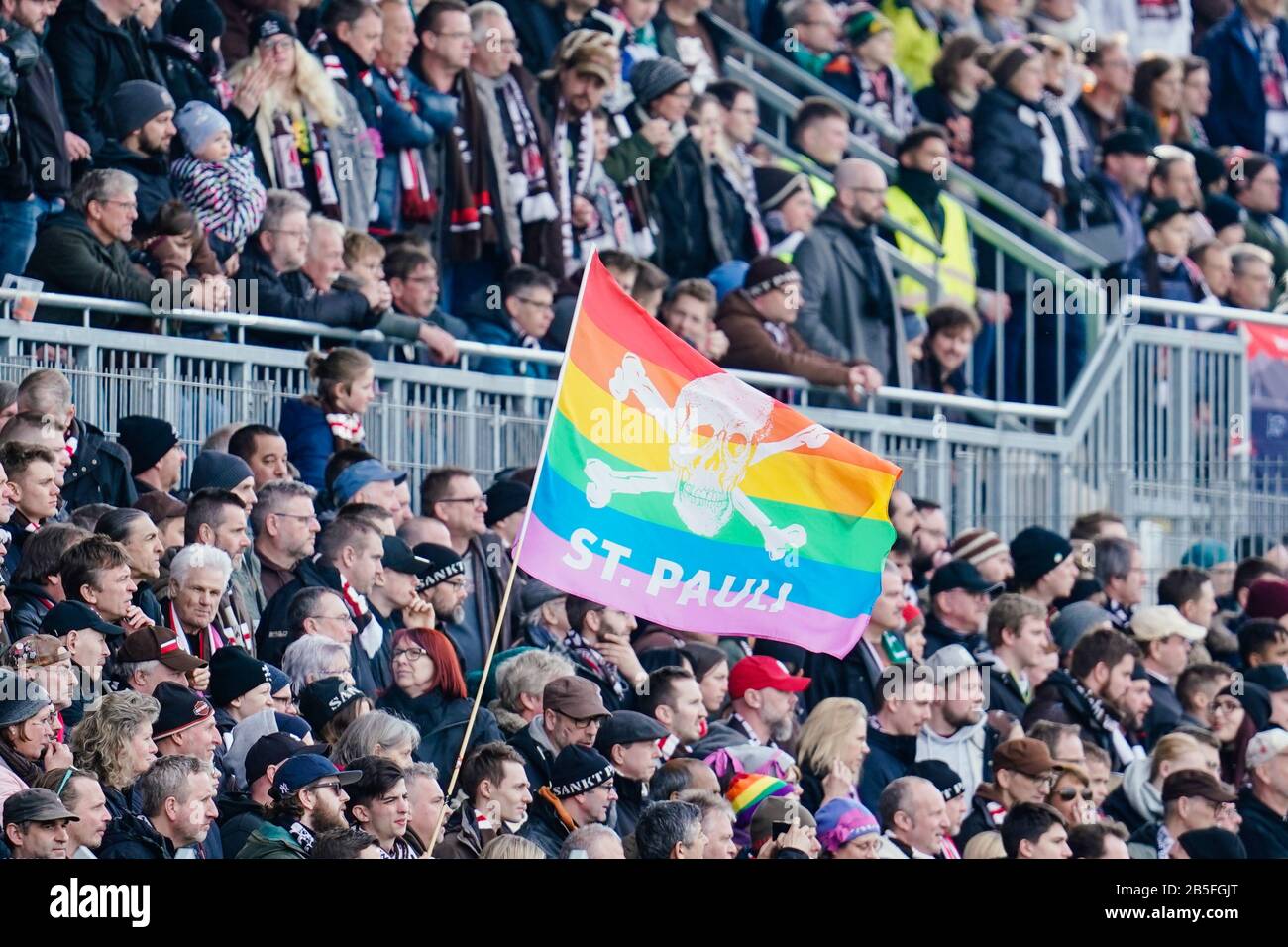 Sandhausen, Germany. 08th Mar, 2020. Football: 2nd Bundesliga, 25th matchday, SV Sandhausen - FC St. Pauli, Hardtwaldstadion. Fans of St. Pauli wave a flag in rainbow colours with the club logo. Credit: Uwe Anspach/dpa - IMPORTANT NOTE: In accordance with the regulations of the DFL Deutsche Fußball Liga and the DFB Deutscher Fußball-Bund, it is prohibited to exploit or have exploited in the stadium and/or from the game taken photographs in the form of sequence images and/or video-like photo series./dpa/Alamy Live News Stock Photo