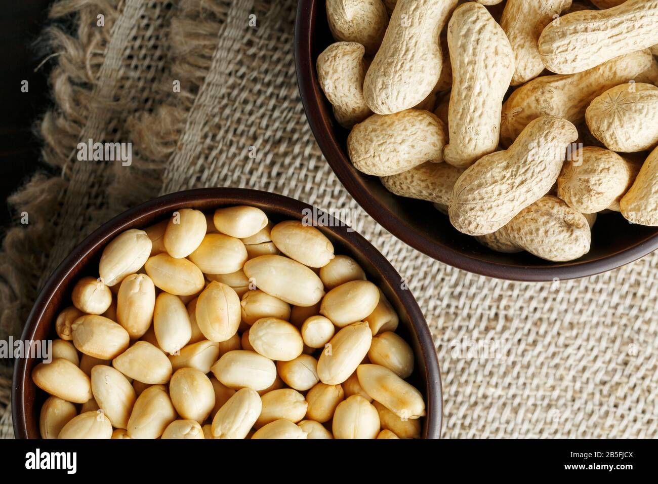 Peanuts in the shell and peeled close up in a cup. Background with