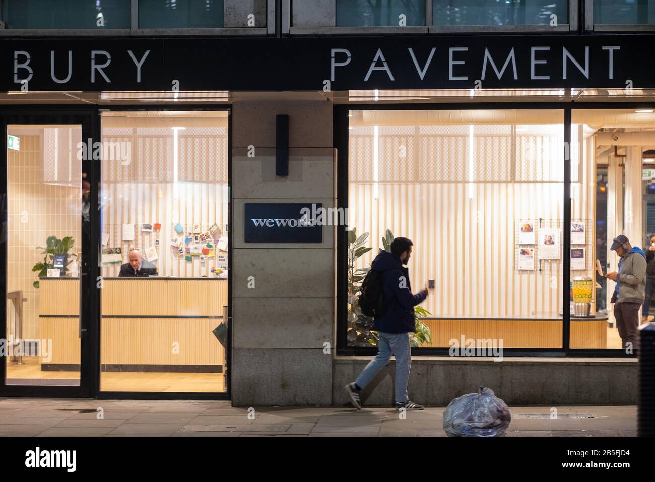 A person walks past a wework office on Finsbury Pavement in the City of London. Stock Photo