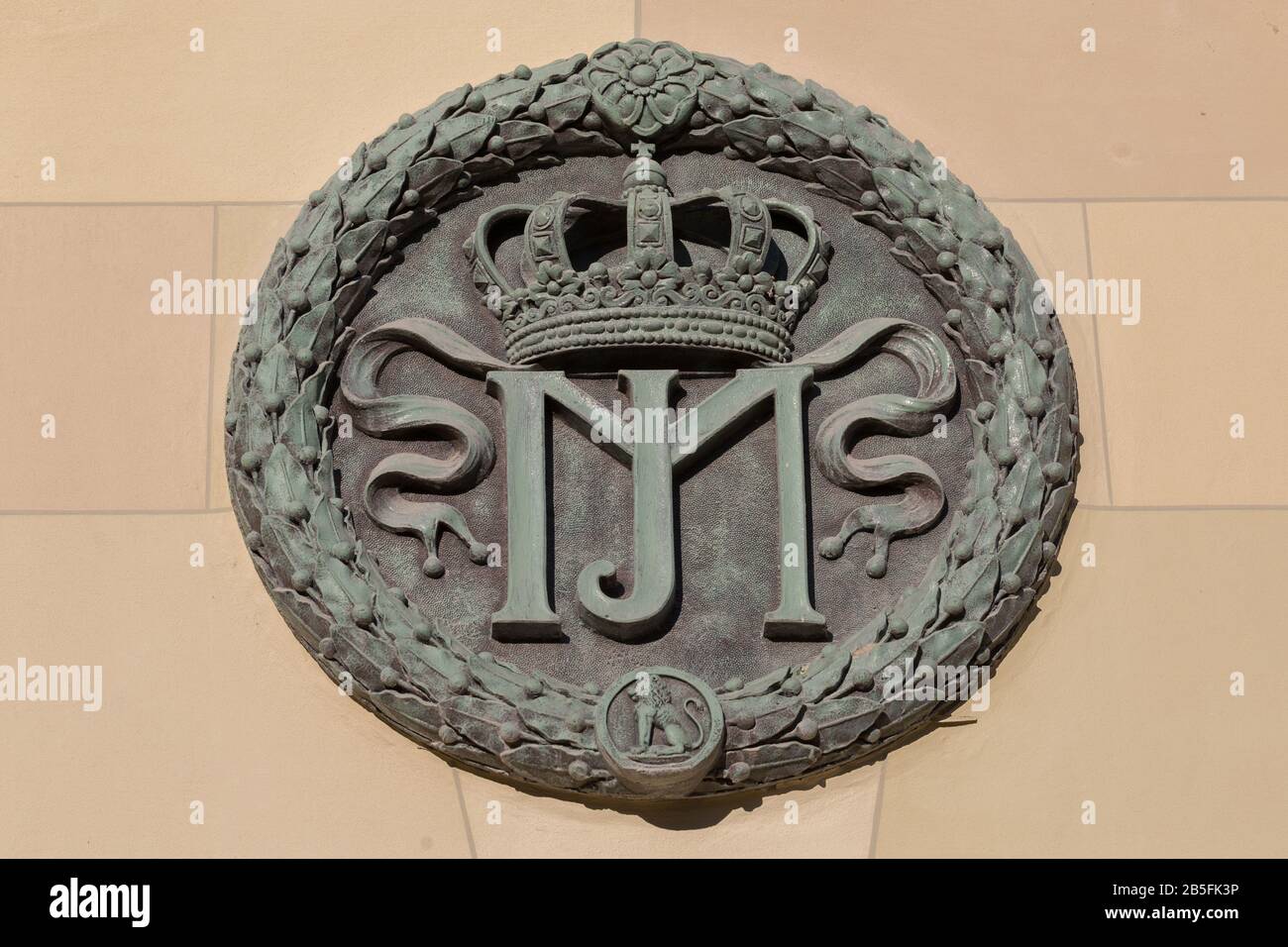 Close up of medallion at main gate of the Hofgarten (Court Garden). With initials MJ (standing for Maximilian I. Joseph), a crown & a lion. Stock Photo
