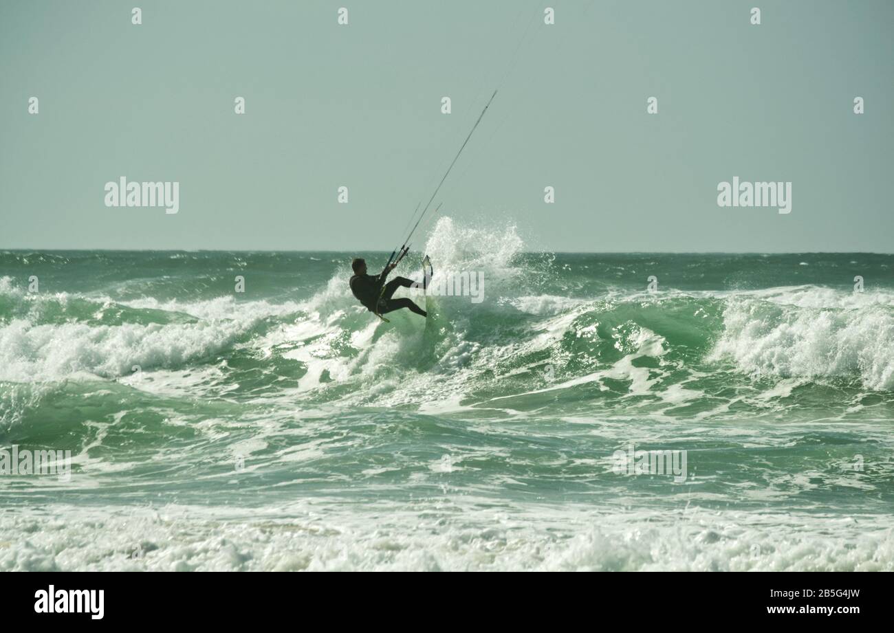 Kite surfer jumping over waves in rough seas at Lacanau-Océan, France Stock Photo
