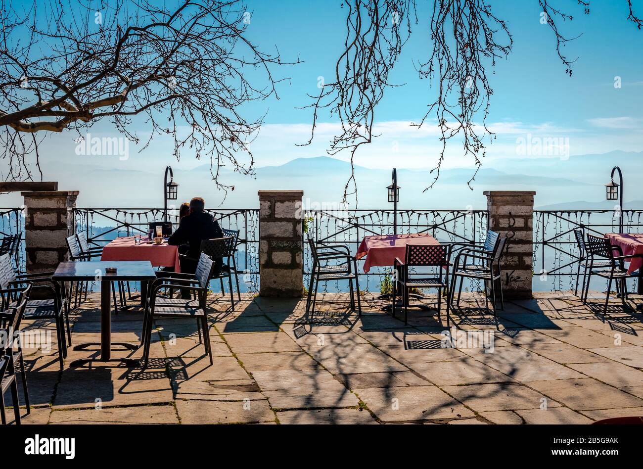 An unidentified young couple enjoys the view from the square in Makrinitsa, a traditional village in Magnesia, Greece. Stock Photo