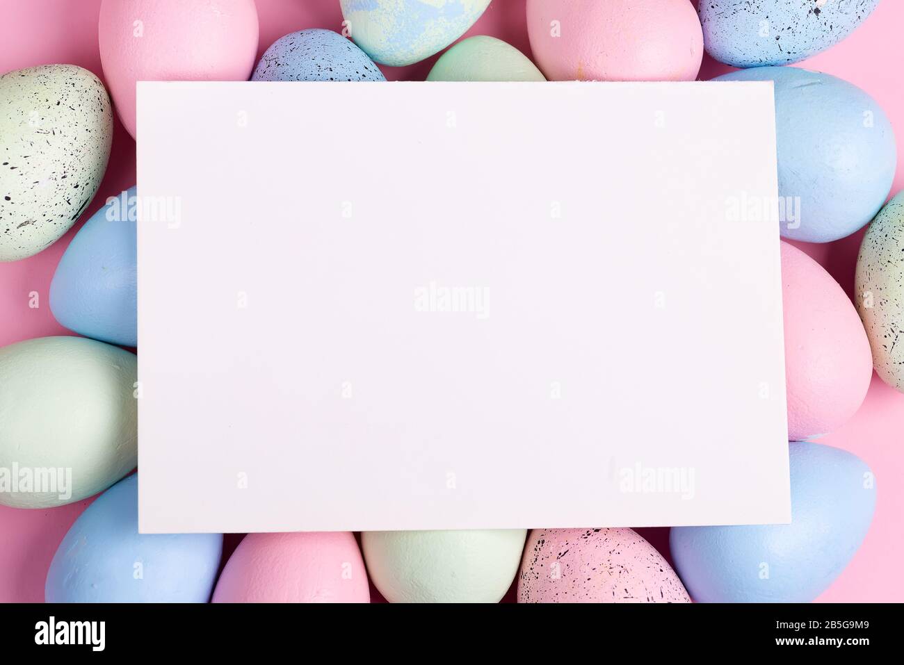 Happy Easter greeting card from handmade painted colorful eggs and paper sheet for congratulation text. Stock Photo