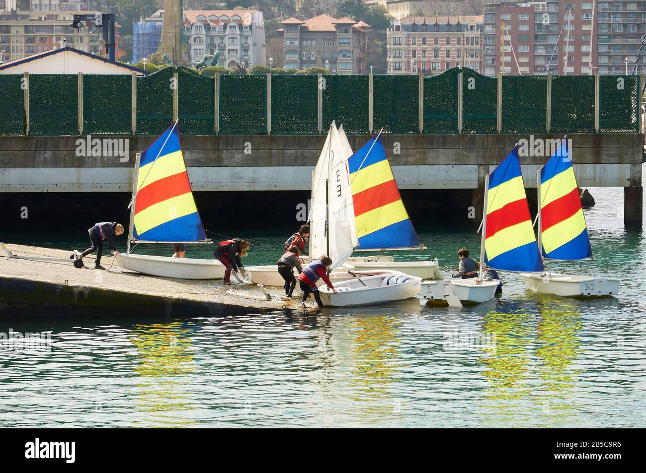 Children preparing optimist sailing boats in a boat ramp for a course at Real Club Marítimo del Abra (Las Arenas, Getxo, Biscay, Basque Country,Spain) Stock Photo