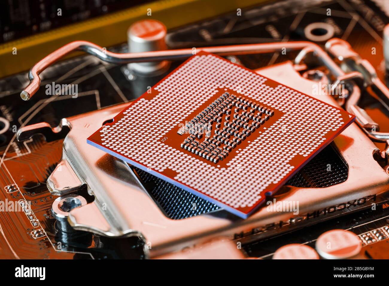 The central processor on the computer motherboard in red colors. PC repair, technician and industry support concept. Stock Photo