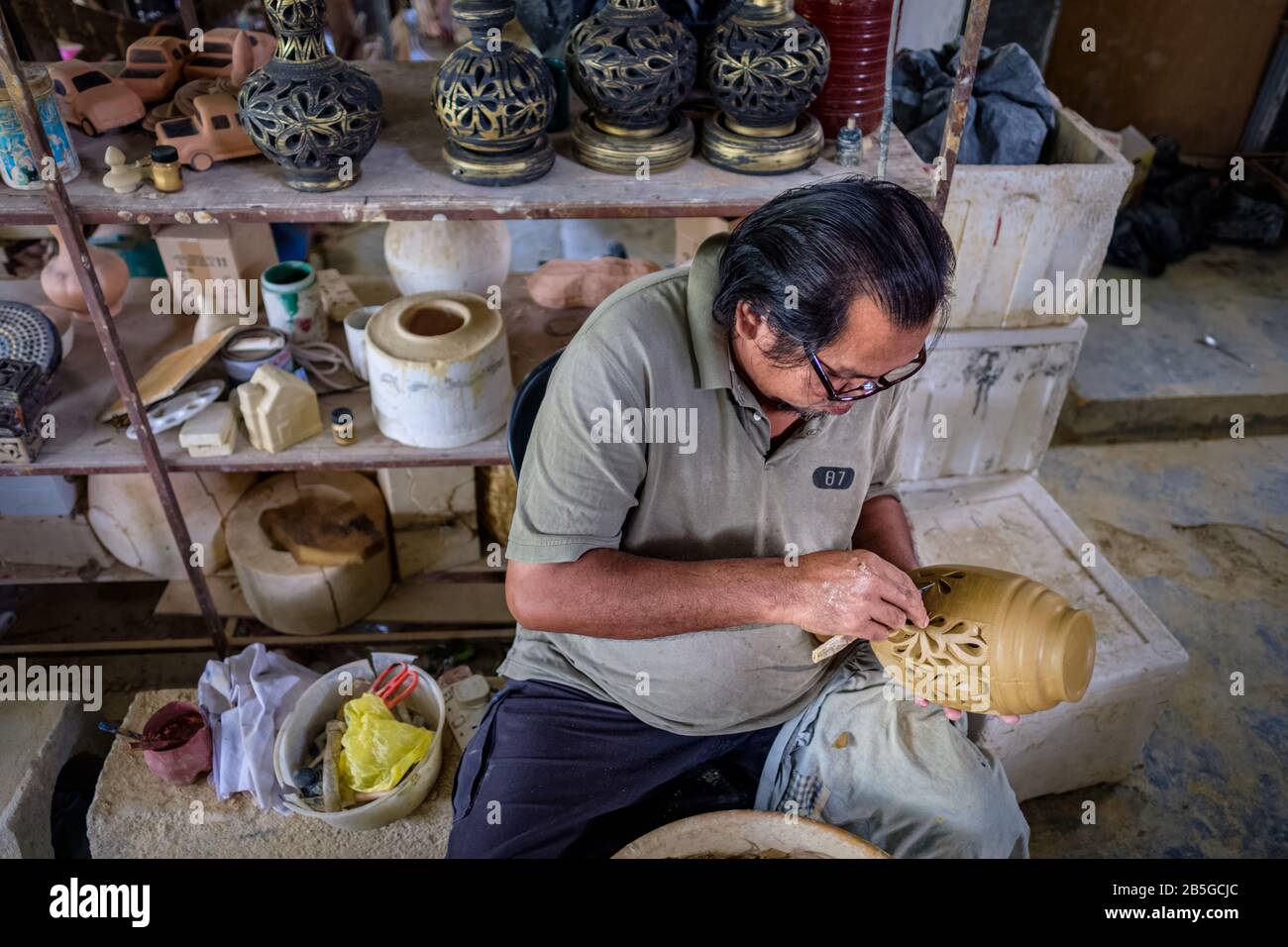 Local craftsman demonstrates on making traditional clay jar called Labu
