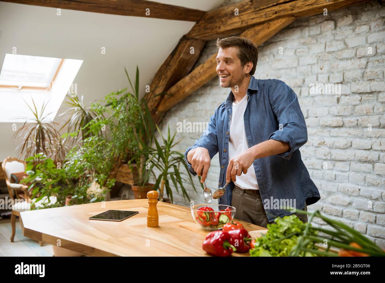 Young man preparing food in the rustic kitchen Stock Photo