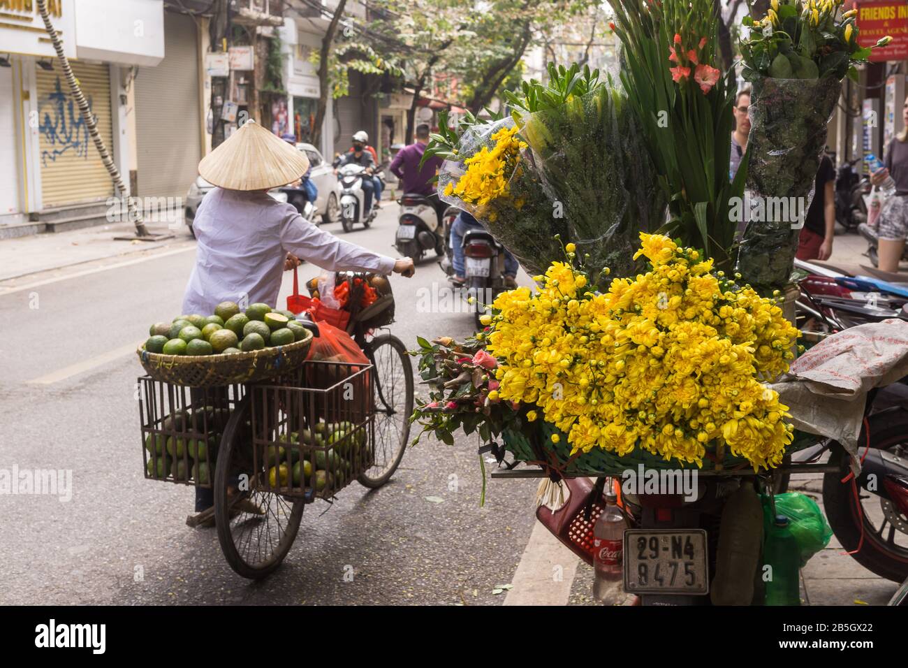 Hanoi street vendor - A street scene in the Old Quarter in Hanoi, fruit street vendor pushing the bicycle. Vietnam, Southeast Asia. Stock Photo