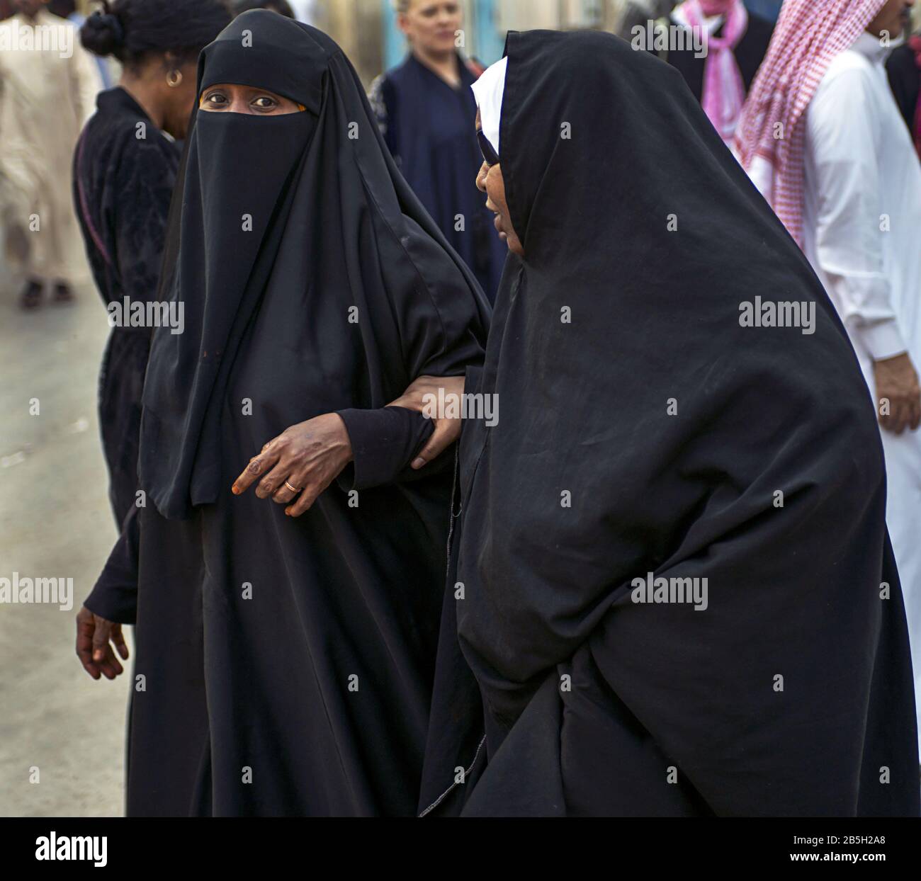 Covered women in Saudi Arabia walking in historic district of Jeddah, Stock Photo