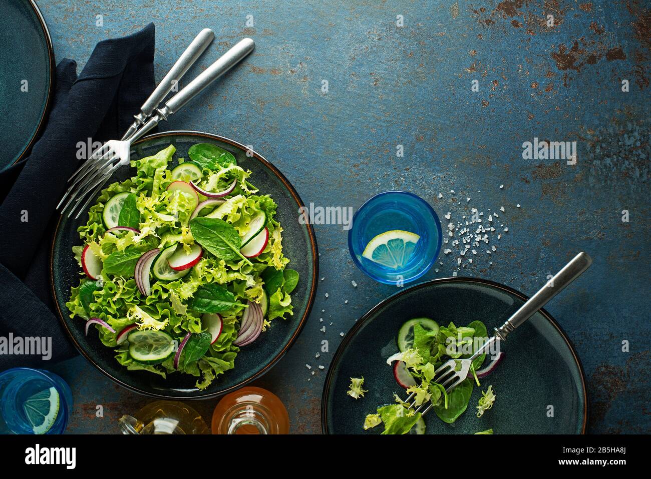 Healthy Green salad with fresh vegetables on blue table background Stock Photo