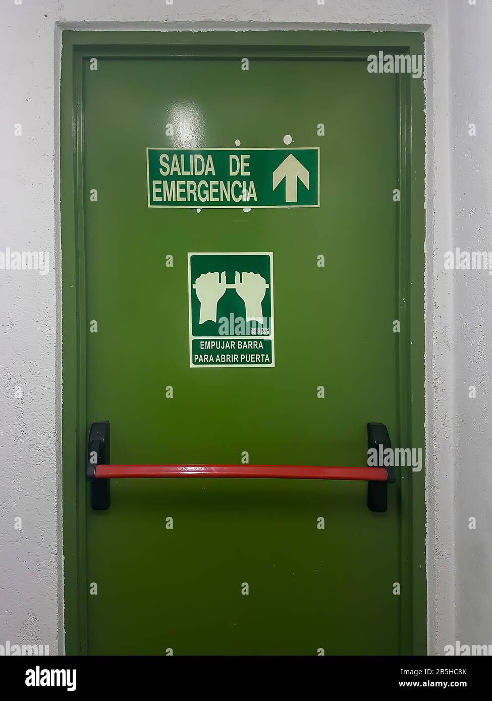 emergency exit with directions in Spanish Stock Photo