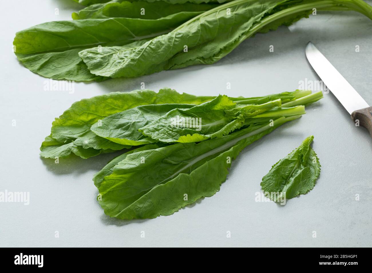 Bunch of fresh raw amsoi leaves on a cutting board Stock Photo