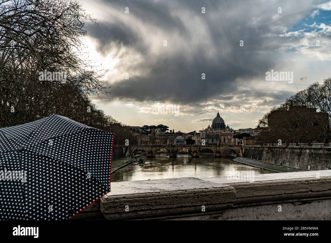woman with umbrella in front of the Papal Basilica of St. Peter, west of River Tiber in Rome, Italy Stock Photo