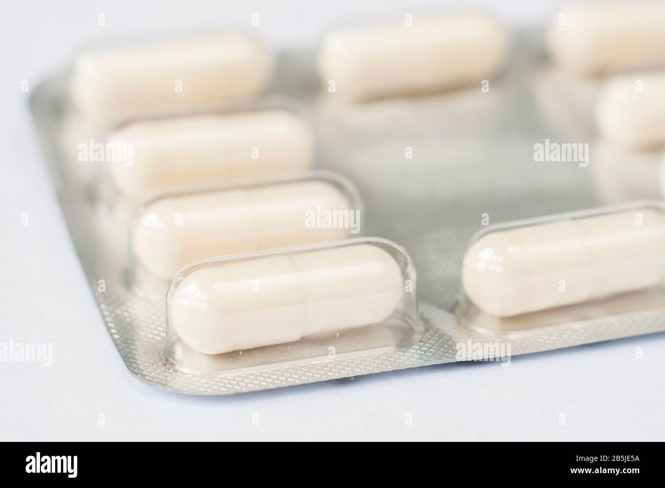 Closeup white antibiotics capsule pills in blister pack. Pharmacy background. Antimicrobial drug resistance. Pharmaceutical industry. Global healthcar Stock Photo