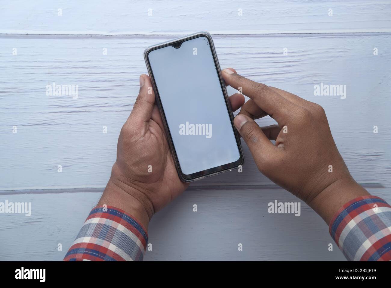 Man using smartphone with blank white screen Stock Photo