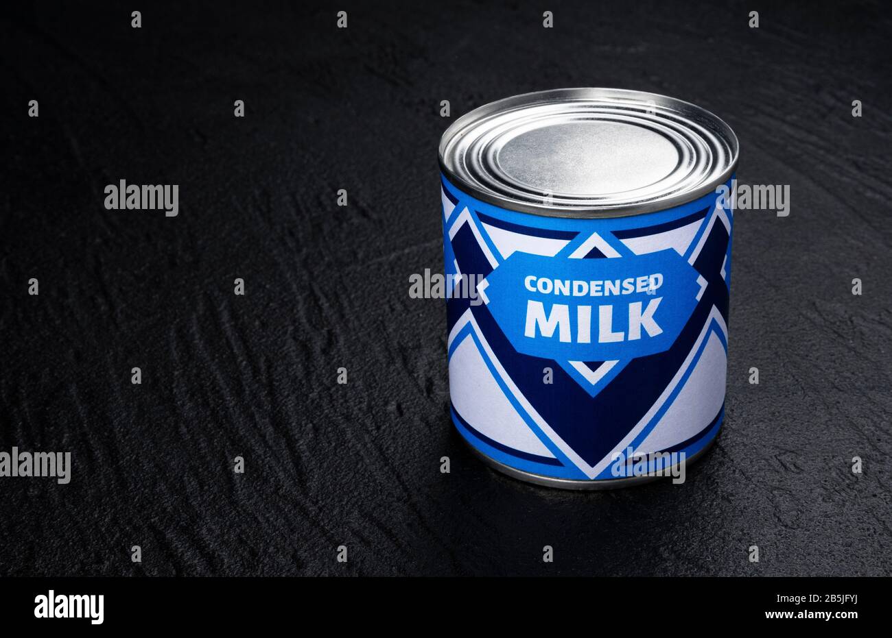 Condensed milk can on black background Stock Photo Alamy