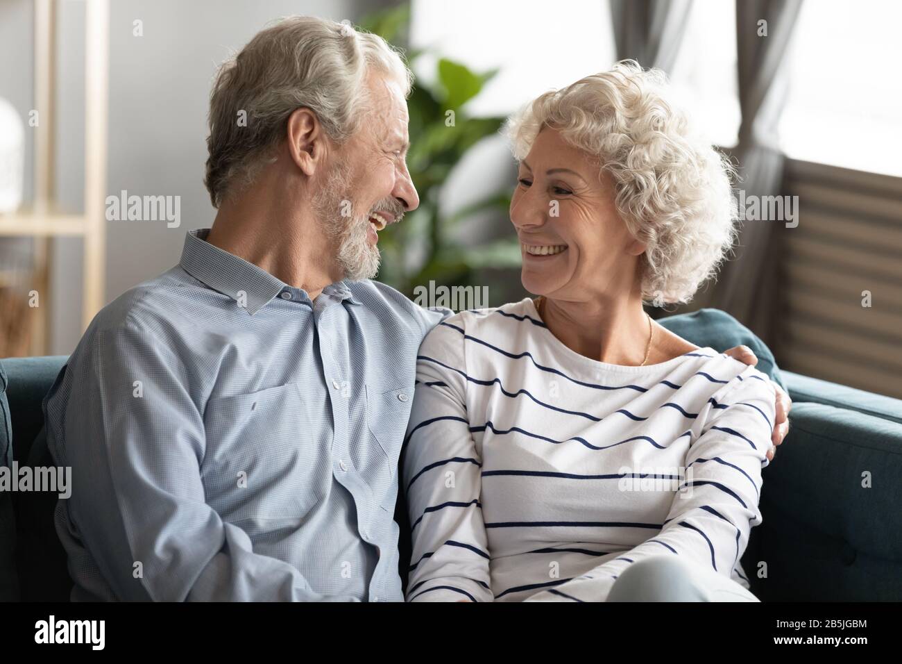 Smiling mature couple relax at home hugging Stock Photo