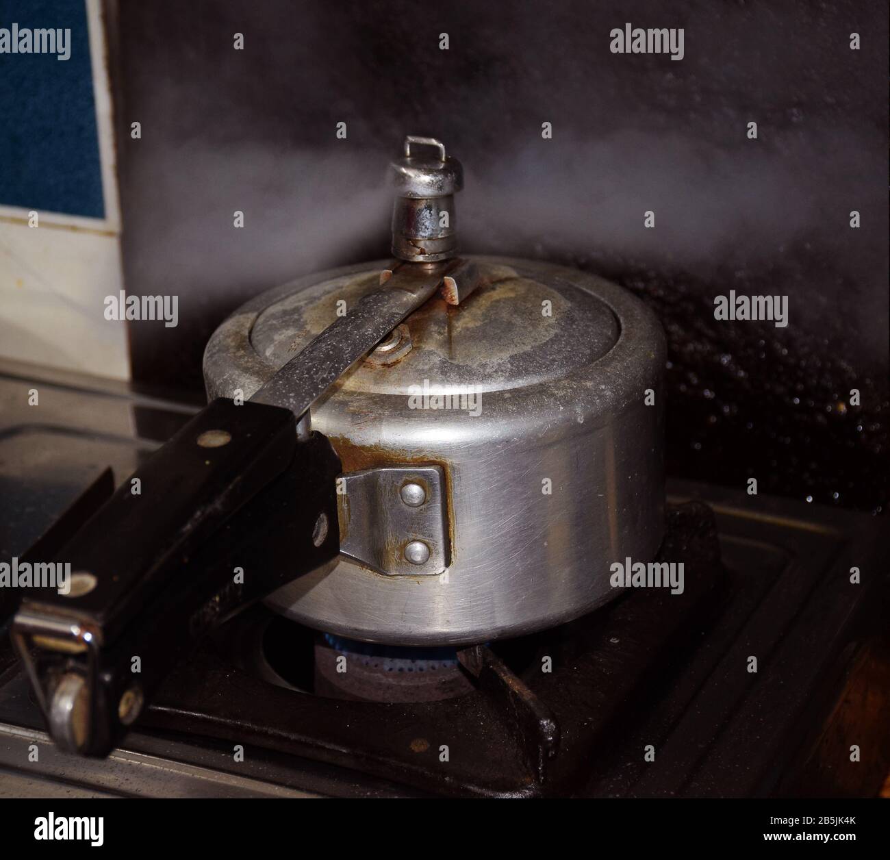 Releasing vapours and steam from pressure cooker lid Stock Photo Alamy