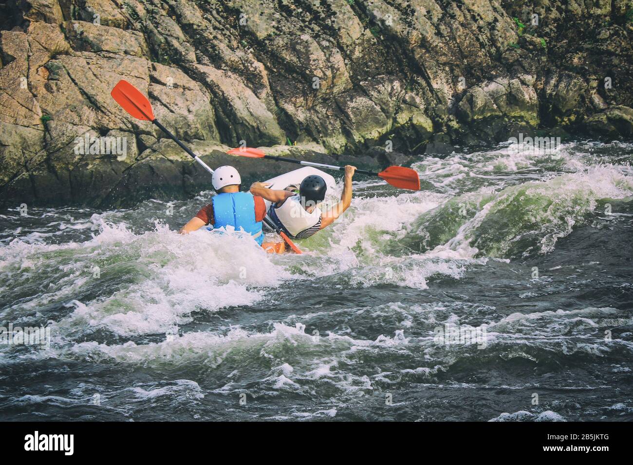 Kayakers fights the white water in a Pivdenny Bug river. They and their