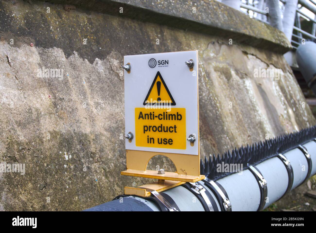 Anti-climb product sign above a pipe on a bridge in the UK Stock Photo
