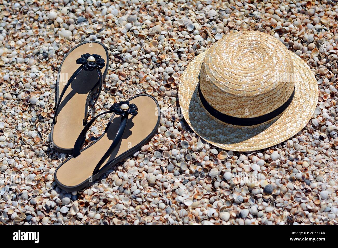 Summer vacation at sea. Hat and flip flops on a sand beach. Sun hat and ...