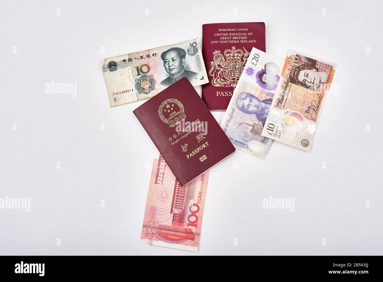 East meets west with Chinese and British passports and british pound and chinese yuan currencies Stock Photo