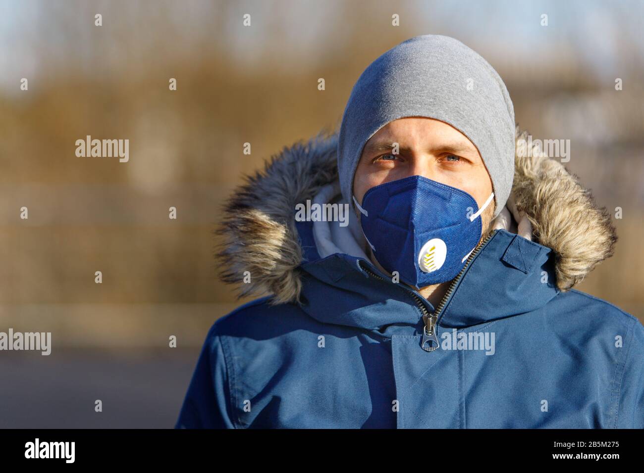 Close up of young man wearing a face mask on the street, looking at camera, copy space. Flu epidemic, dust allergy, protection against corona virus. C Stock Photo