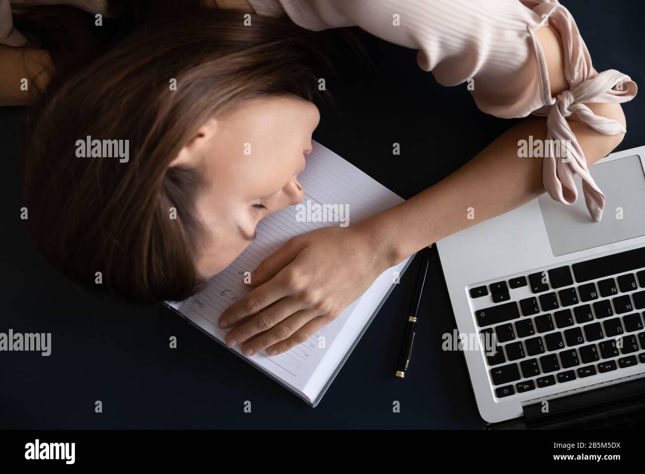 Top above view restless young woman freelancer sleeping on table. Stock Photo