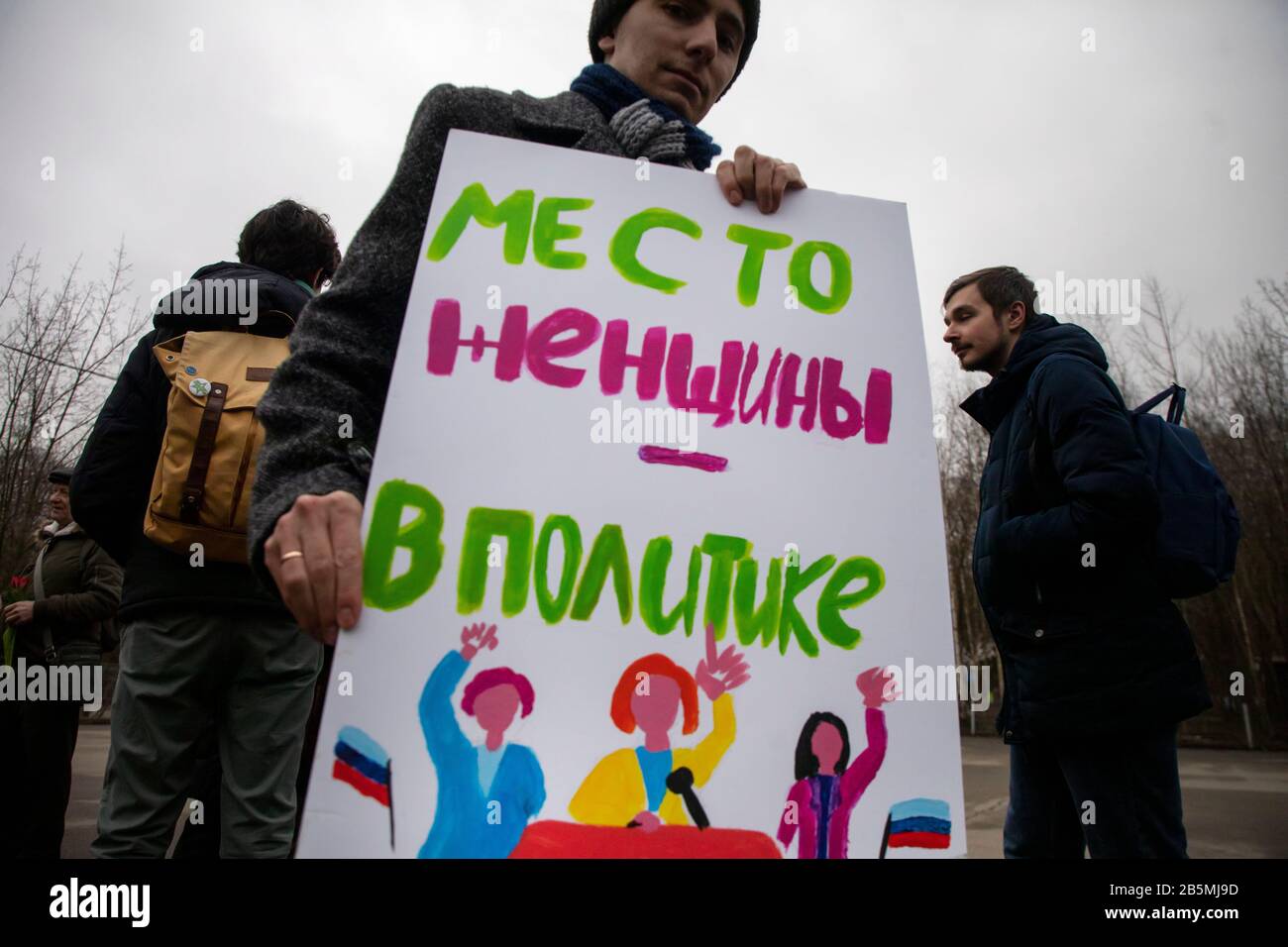Moscow, Russia. 8th of March, 2020 A participant in a rally 'March 8 - celebrate the holiday correctly' for women's solidarity and women's rights, organized by the group of female activists to mark International Women's Day in Moscow's Sokolniki Hyde Park.The protesters stand out for a draft law protecting women from domestic violence, for equality, against sexism, female objectification, and political repression. The banner reads 'A woman's place in politics' Stock Photo
