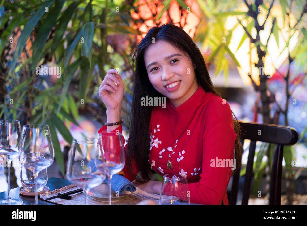 A young Vietnamese woman wearing a traditional red Ao Dai dress Stock Photo