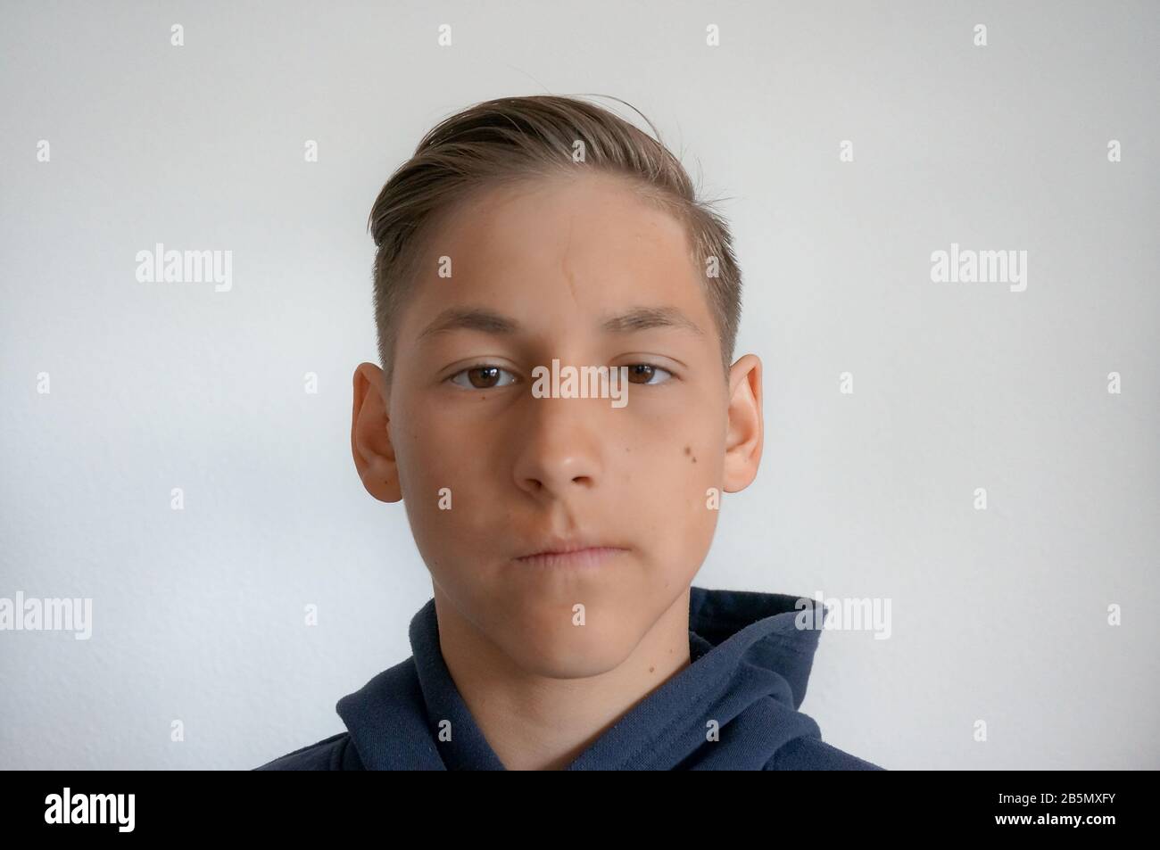 Portrait of teenager boy on white background wearing hoodie Stock Photo
